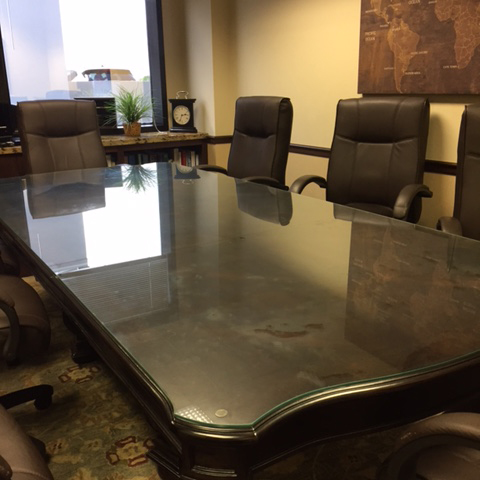 The dark brown wood boardroom table at Herman Law